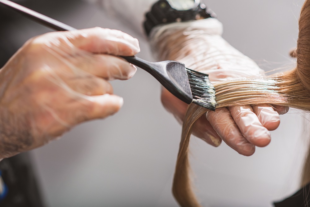 Hairdresser is dying female hair